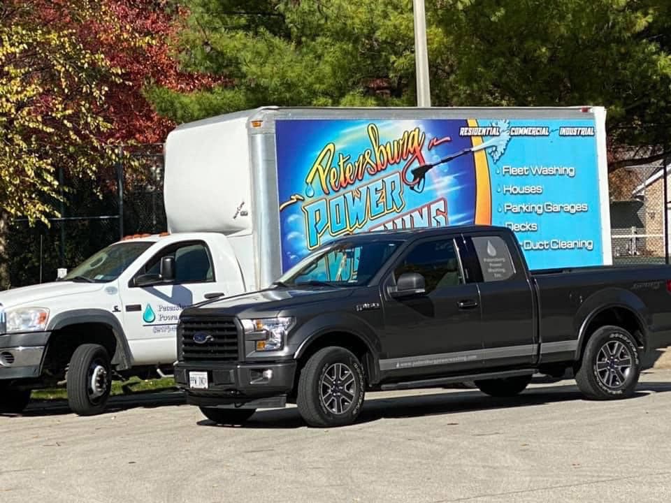 petersburg power washing truck next to a black pickup truck