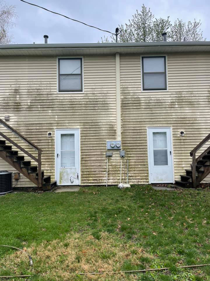 A before image of a duplex home covered in algae and dirt. A house in Springfield, IL, that requires a power washing service from professionals.
