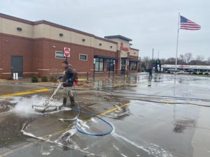 This is a picture of Petersburg Power Washing employee Phil Miller pressure washing the Chick-fil-A parking lot in Springfield, IL.