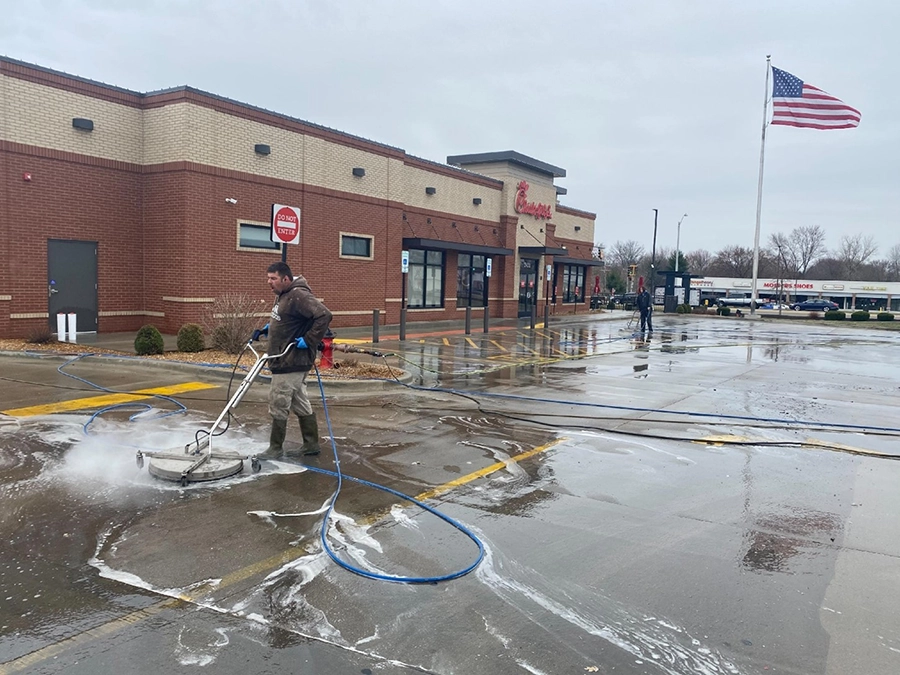 This is a picture of Petersburg Power Washing employee Phil Miller pressure washing the Chick-fil-A parking lot in Springfield, IL.